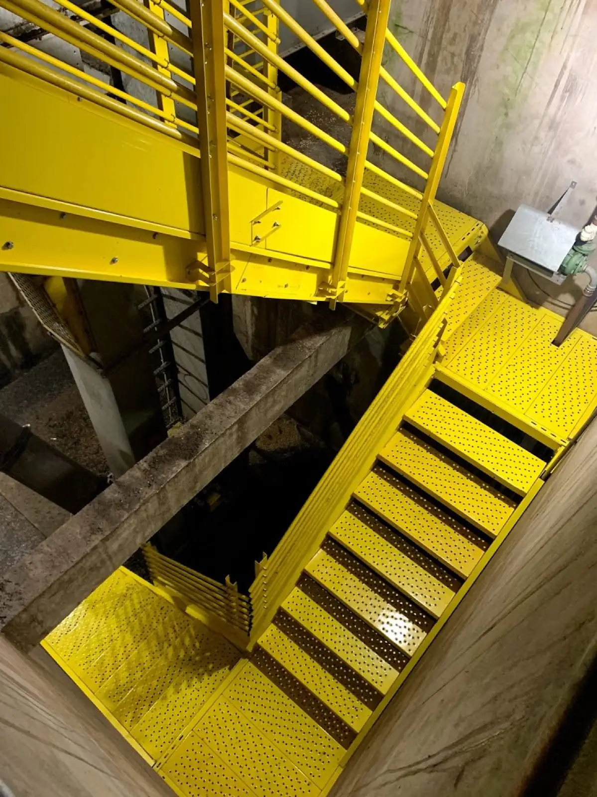 Escada de acesso industrial em amarelo dentro de estrutura de silo, obra real Pazini Engenharia