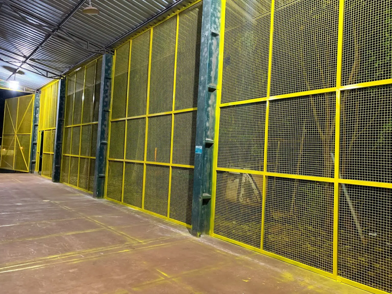 Fechamento industrial em tela metálica amarela para proteção de máquina, obra real Pazini Engenharia