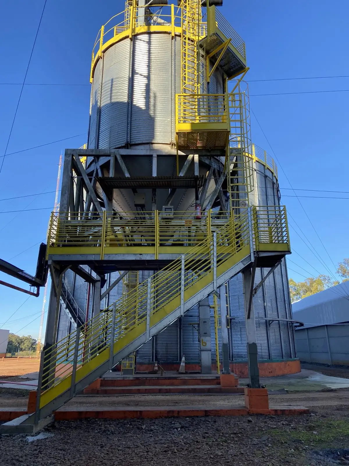 Silo de armazenagem de grãos com estrutura metálica e escada de acesso, obra real Pazini Engenharia